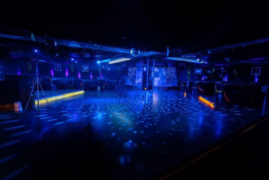 Empty nightclub dance floor with blue lights.
