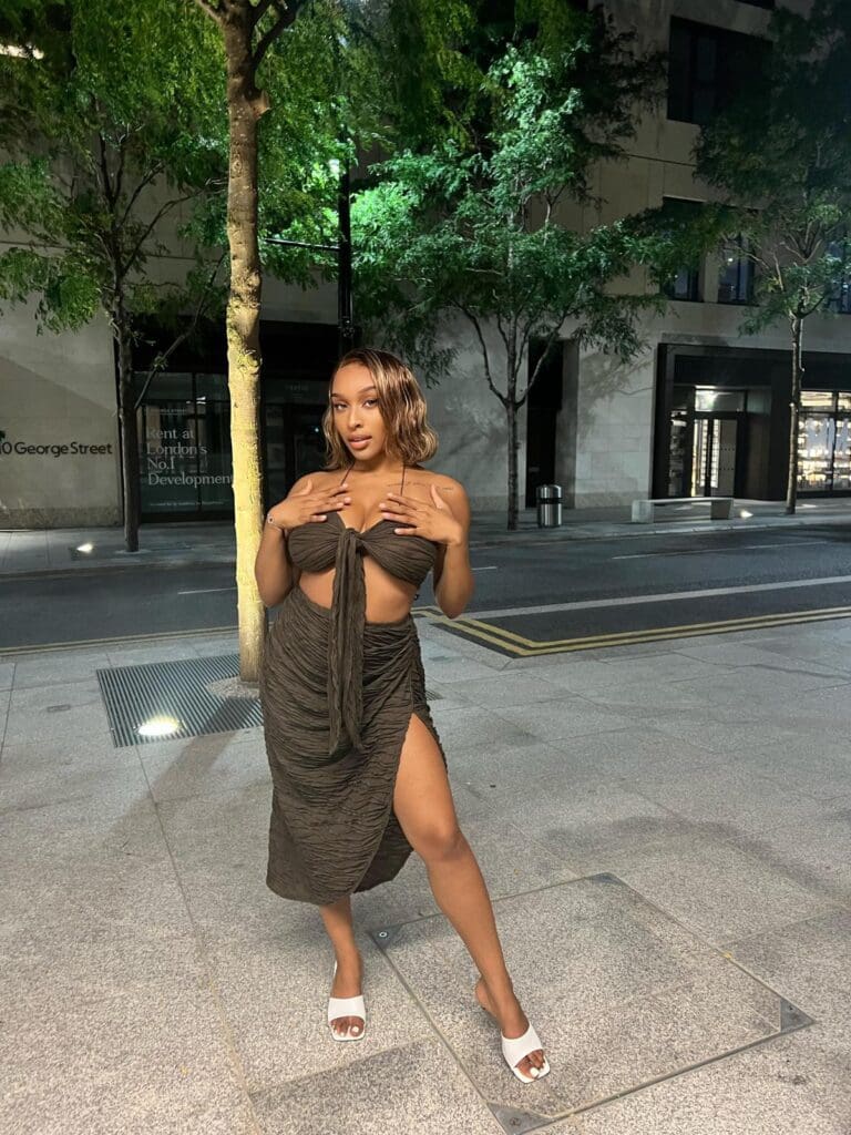 Woman posing in stylish dress outdoors.