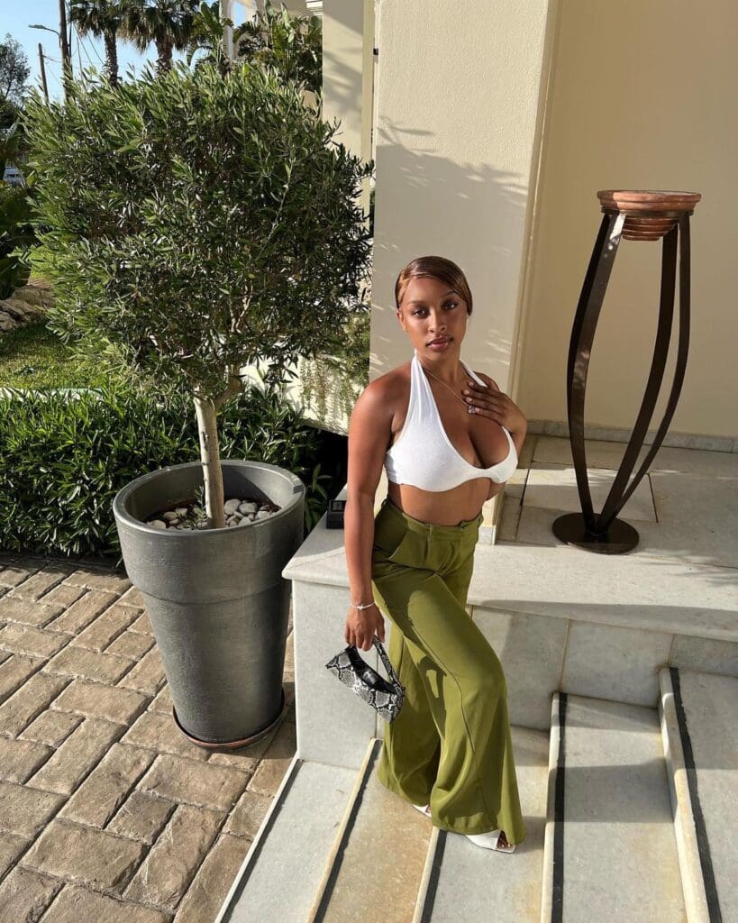 Woman posing outdoors in stylish outfit.