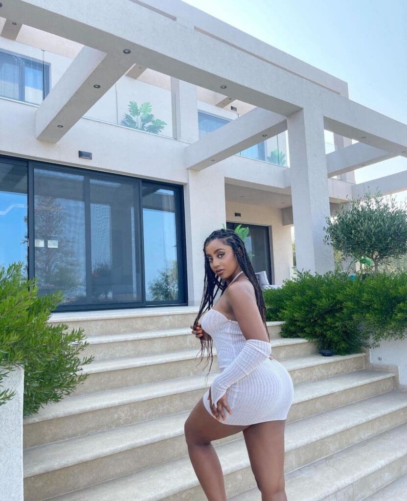 Woman posing on outdoor staircase, modern house.