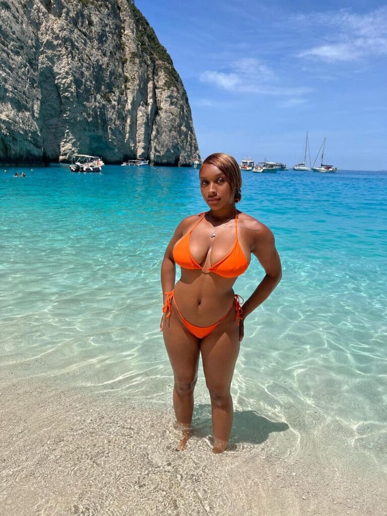 Woman in orange bikini on a beach.