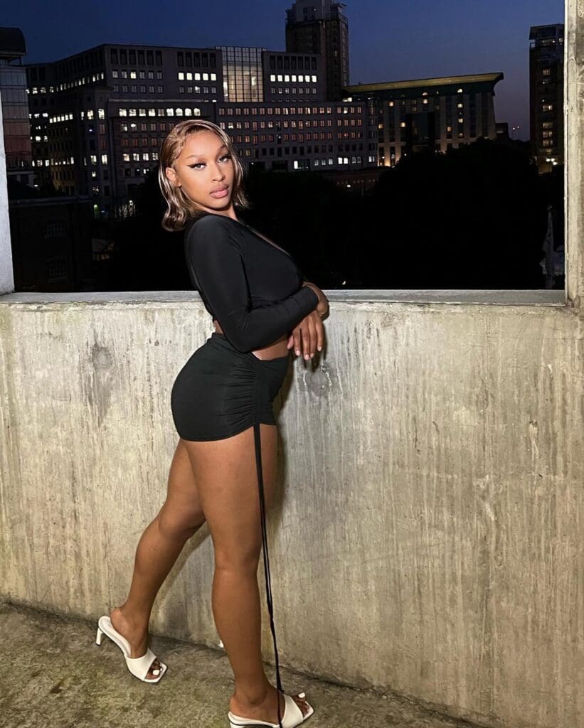 Woman posing on rooftop at night.
