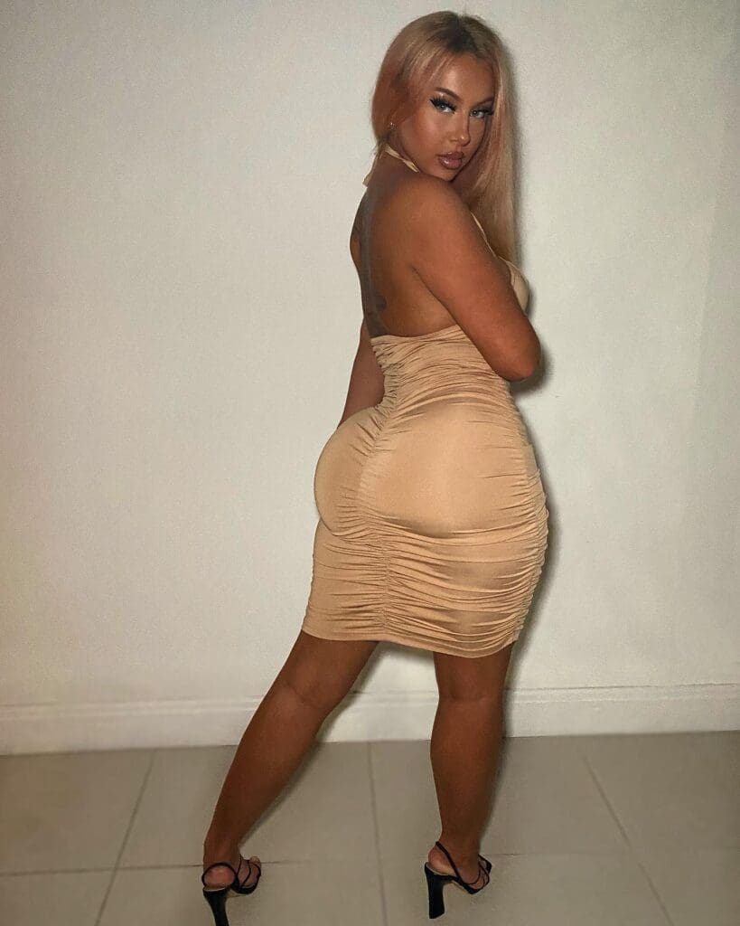 Person in beige dress posing confidently.