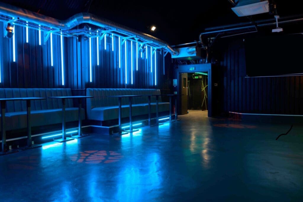 Empty nightclub with blue neon lighting.