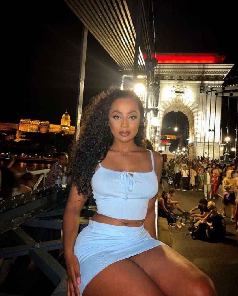 Woman posing on a bridge at night.