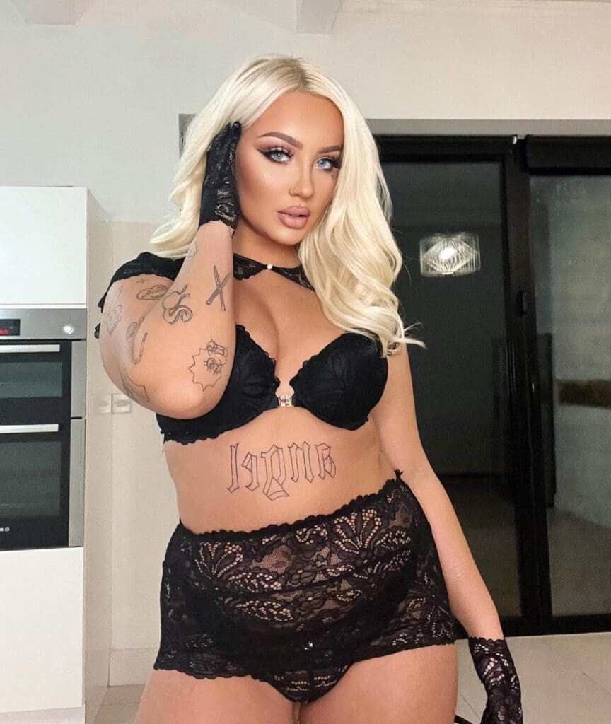 Woman in black lace lingerie posing indoors.
