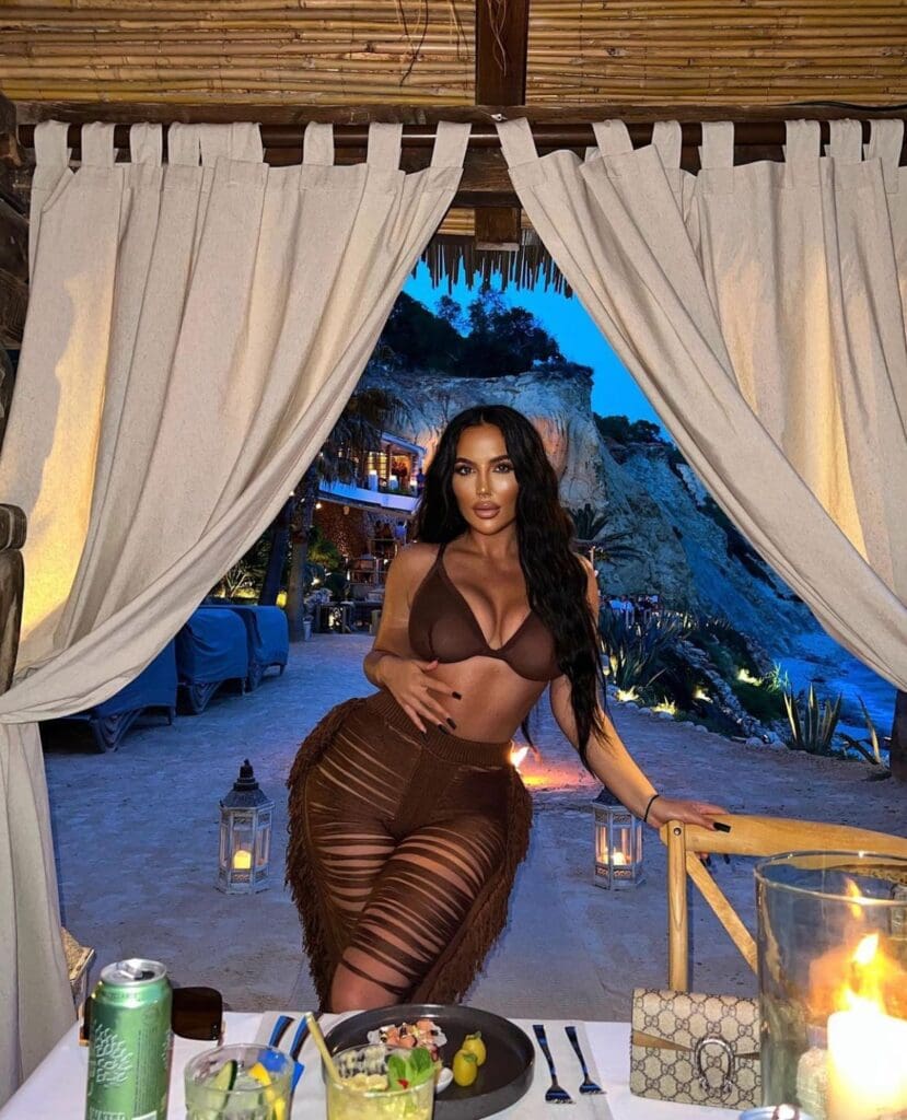 Woman posing at beachside restaurant during evening.