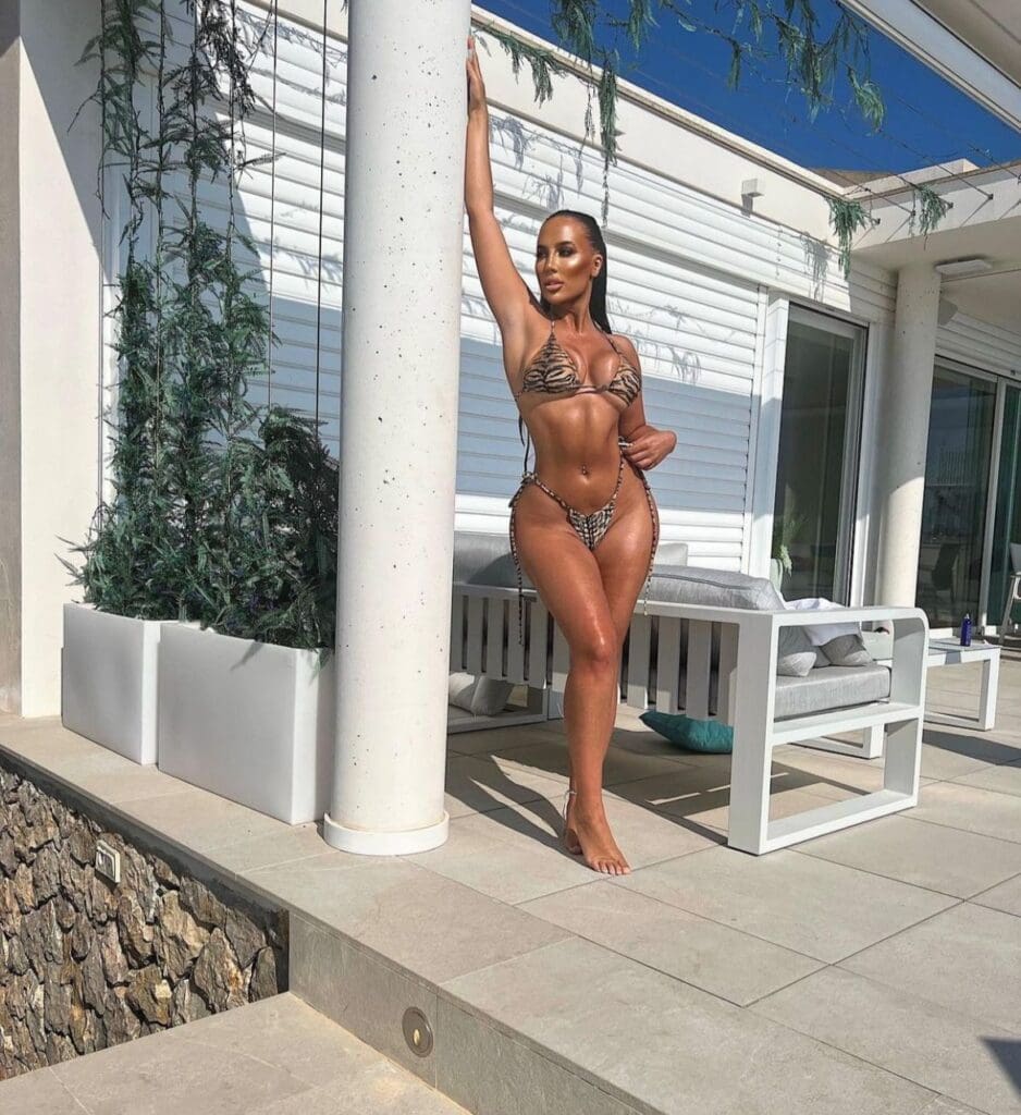 Woman in bikini posing by patio column.