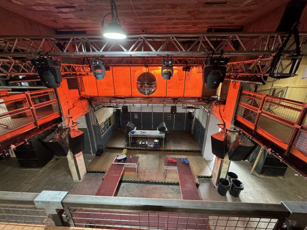 Empty nightclub stage with red lighting.
