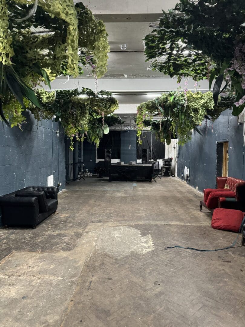 Industrial space with hanging plants and couches.