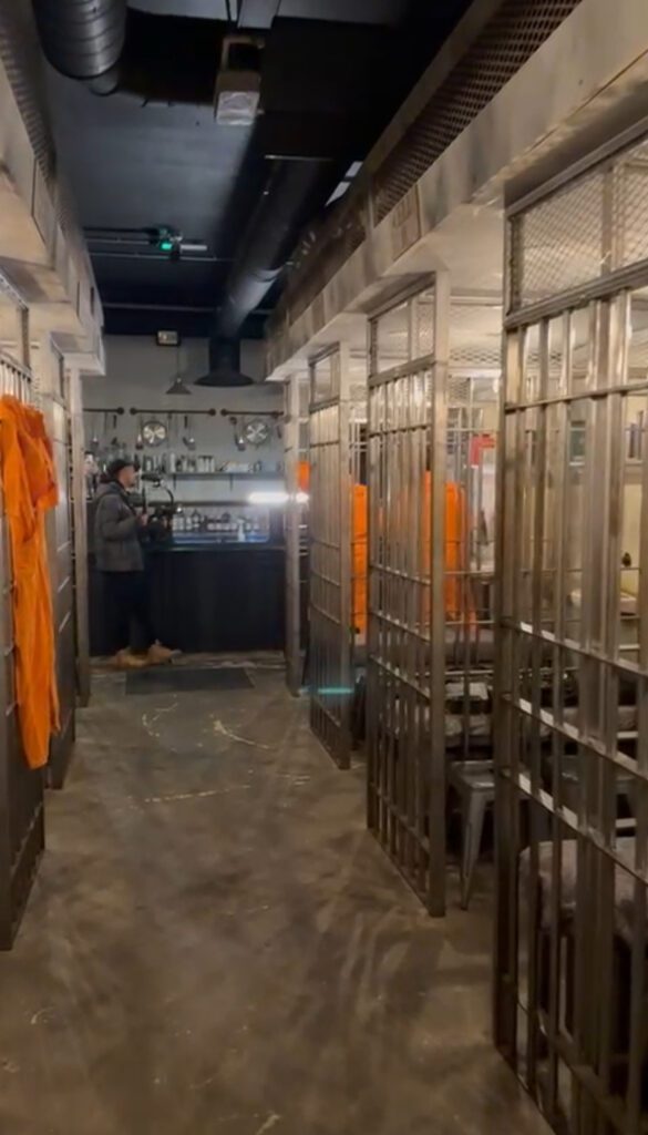 Prison-themed bar with cells and decorations.