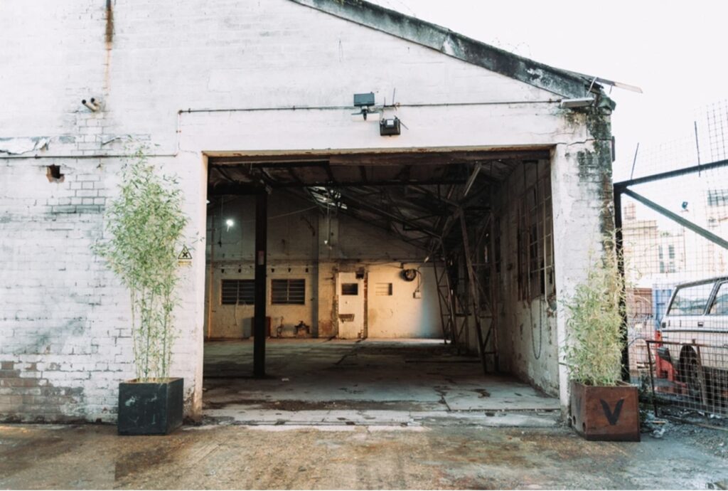 Empty warehouse with open garage door.