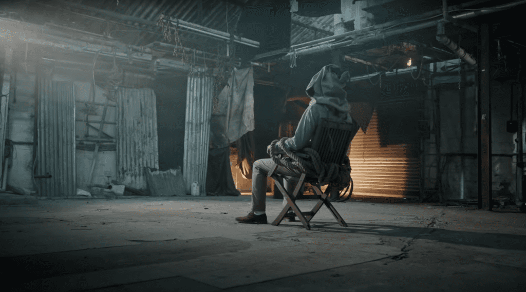 Person sitting in dark, abandoned warehouse.
