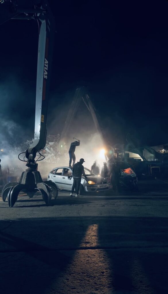 Nighttime construction scene with machinery and workers.