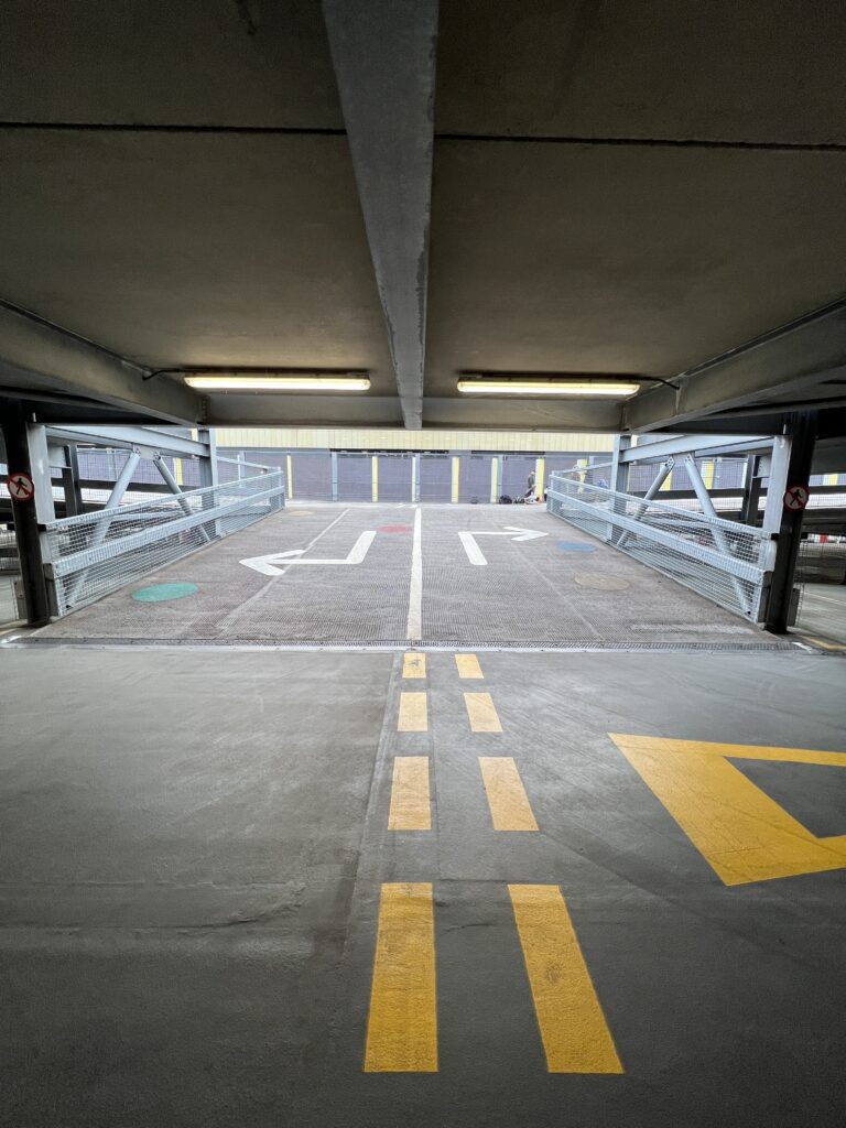 Parking garage with yellow directional arrows.