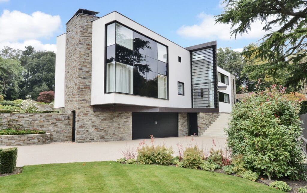 Modern house with large windows and garden.