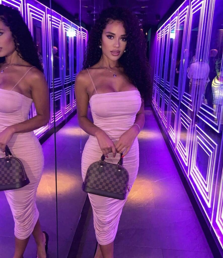 Woman in pink dress with handbag.