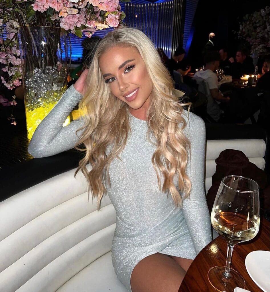 Woman in a silver dress at a restaurant.