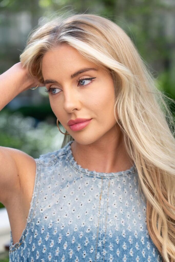 Woman with long blonde hair looking pensively.