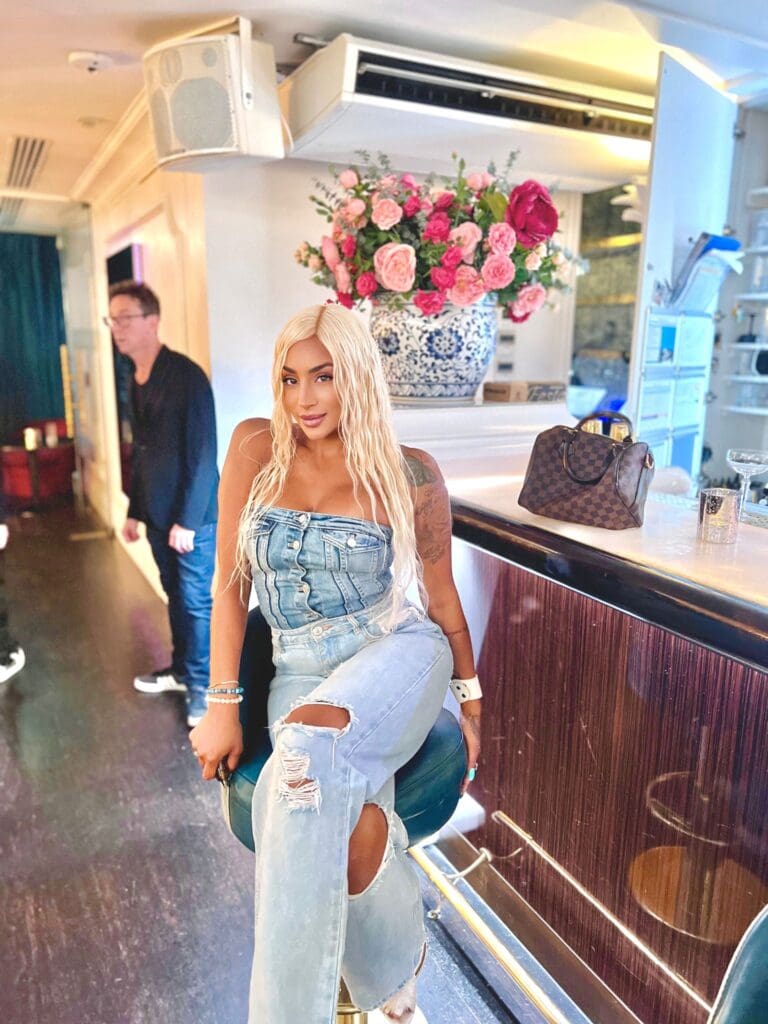 Woman in denim outfit near bar counter.
