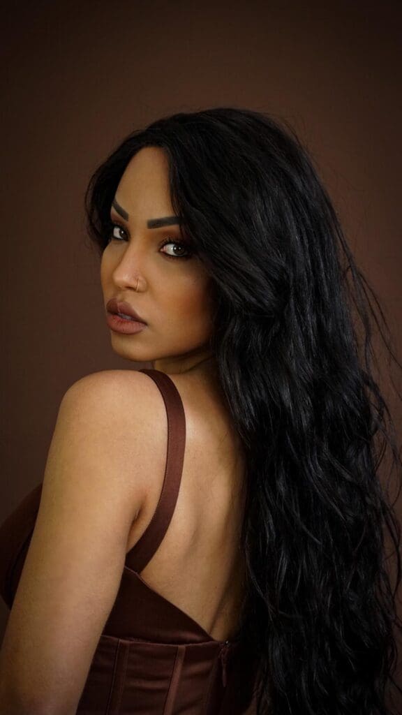 Woman with long black hair, brown dress.