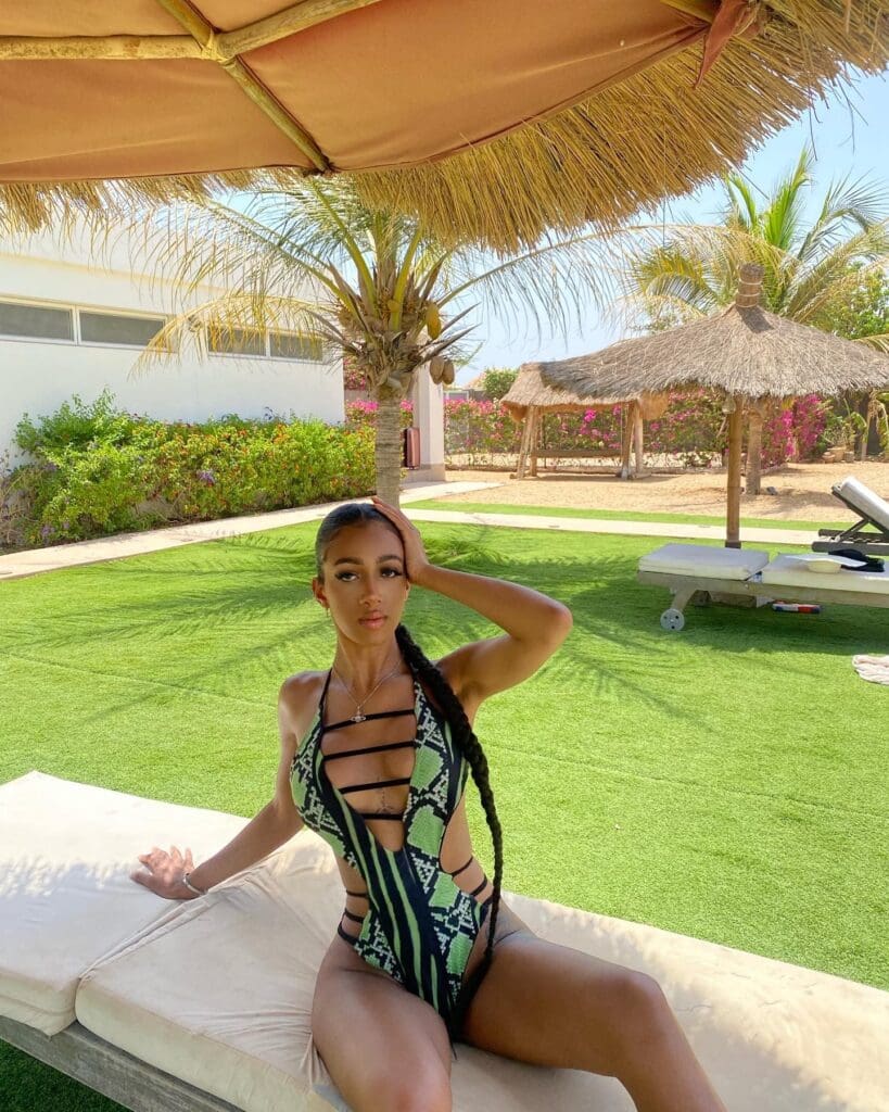 Woman in swimsuit relaxing by poolside.