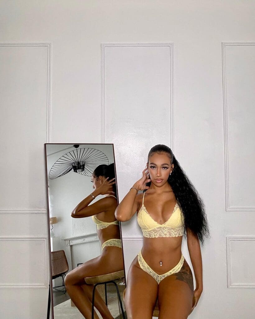 Woman in yellow lingerie near mirror.