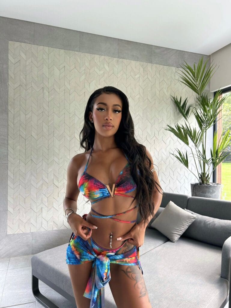 Woman in colorful bikini by indoor plant.