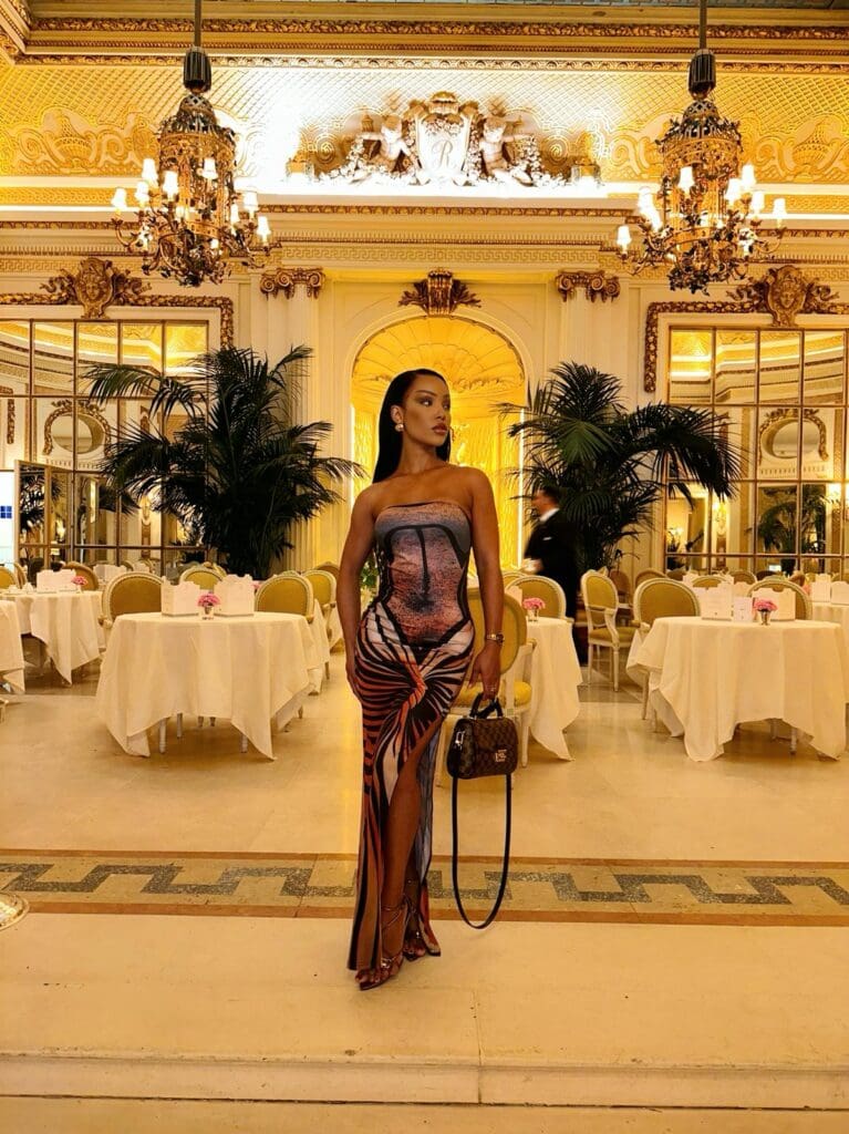 Elegant woman in opulent dining room setting.