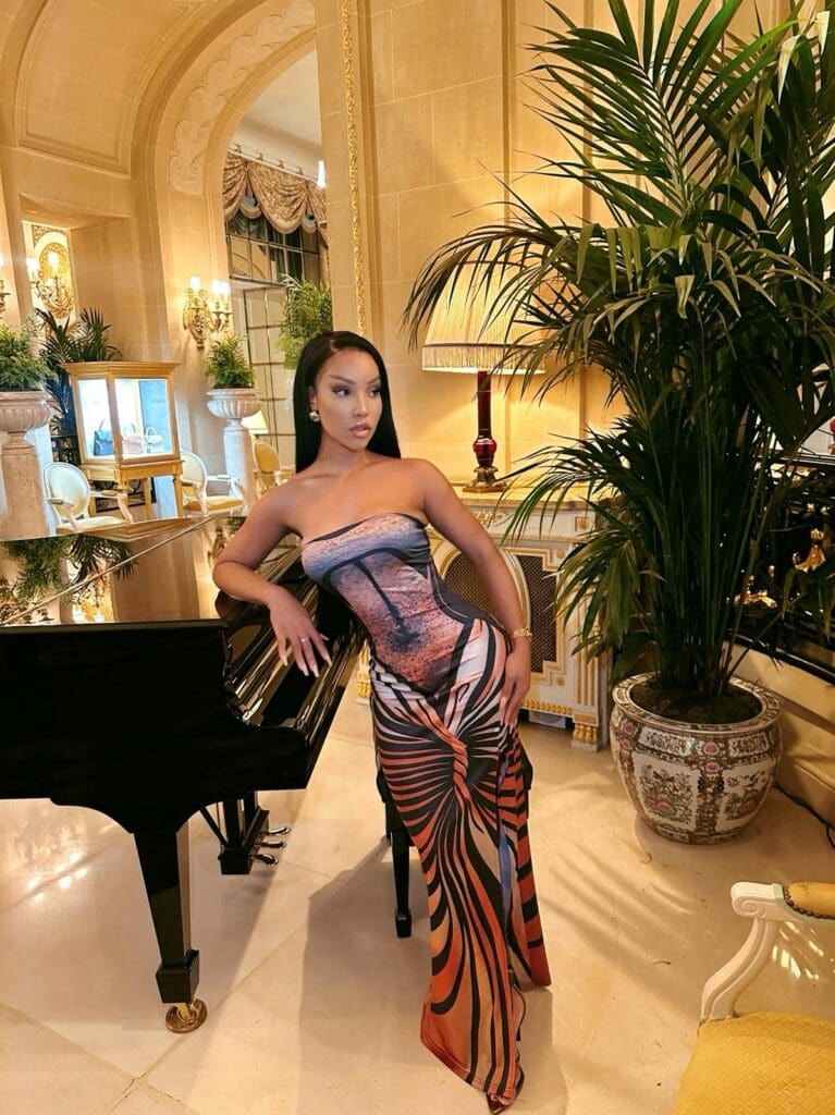 Woman in elegant dress beside grand piano.