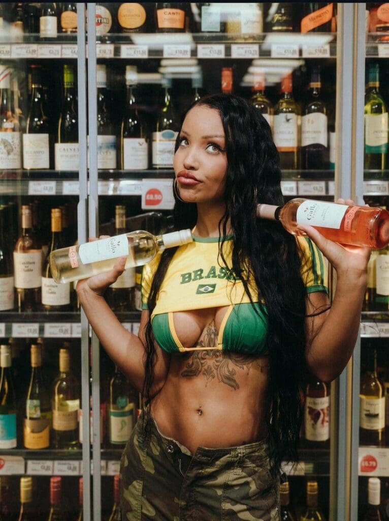 Woman holding wine bottles in liquor store.