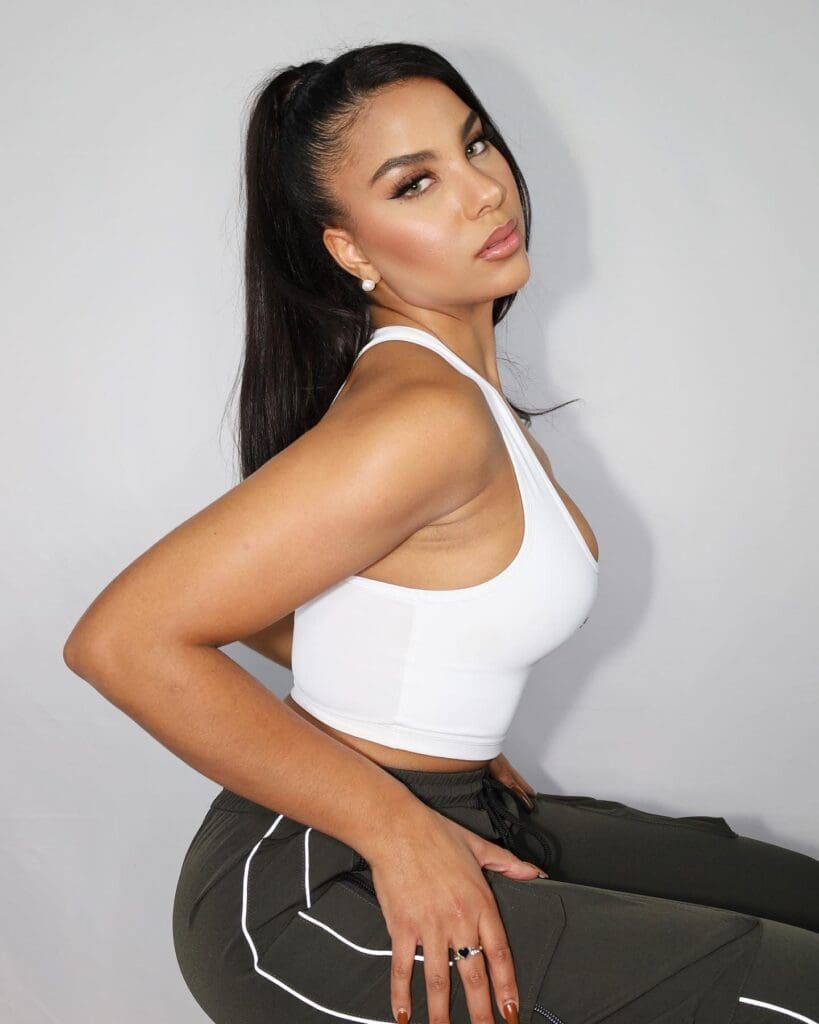 Woman in white top posing confidently.