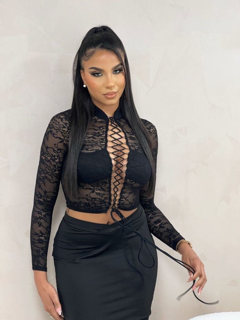 Woman in black lace top and skirt.