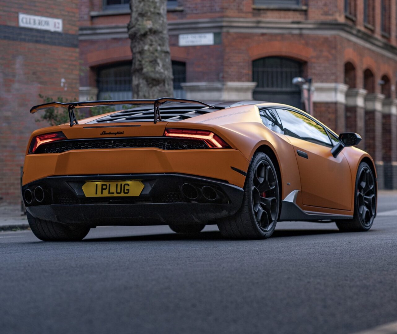 Orange sports car parked on city street.