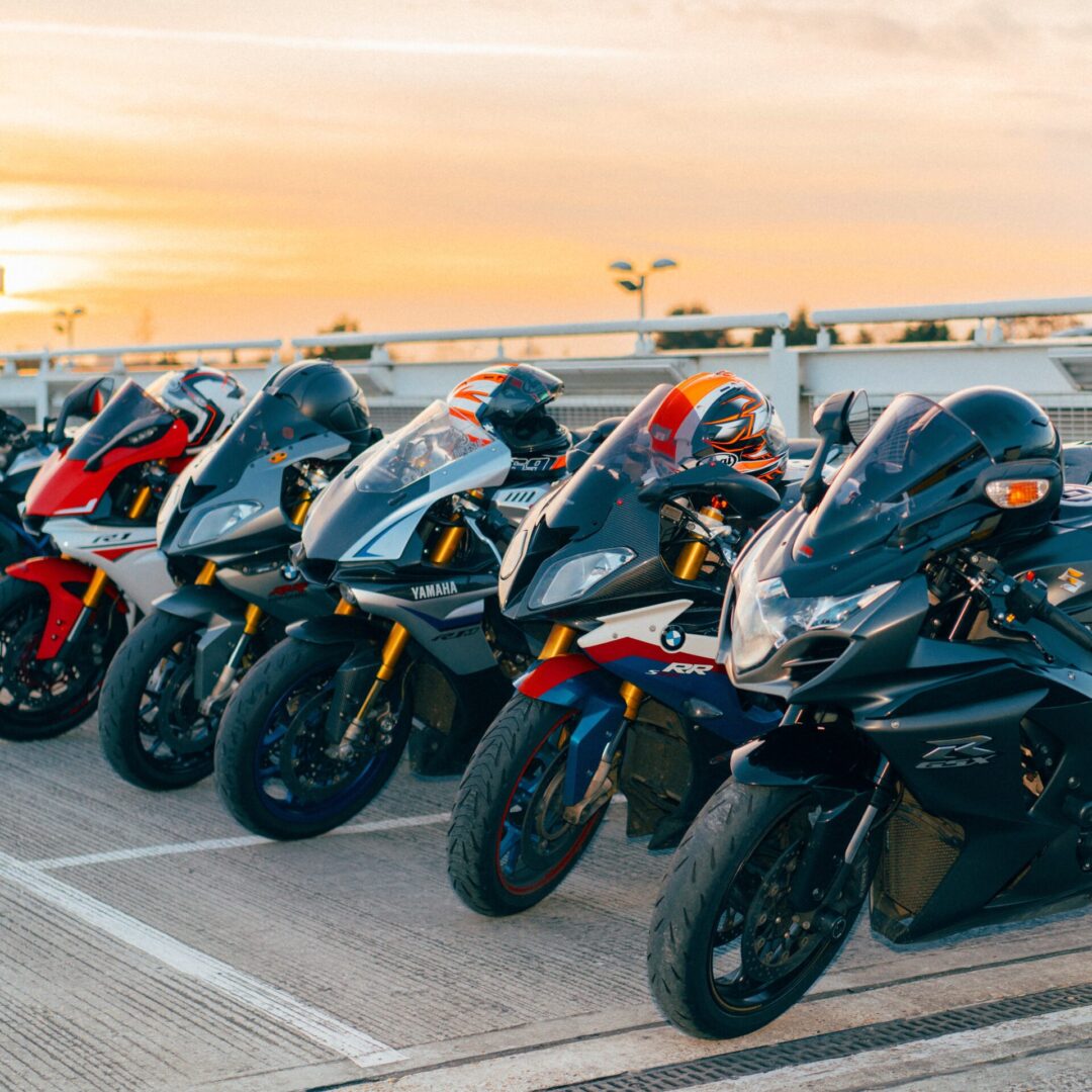 Motorcycles parked in a row at sunset.